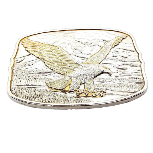Front view of the retro vintage eagle belt buckle. It is mostly silver tone in color with some gold tone around the edge and some of the feathers on the flying eagle.