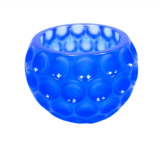 Side view of the handmade resin decorative bowl. The resin is semi translucent neon blue in color. The bowl is rounded and has an indented dot design all the way around it.