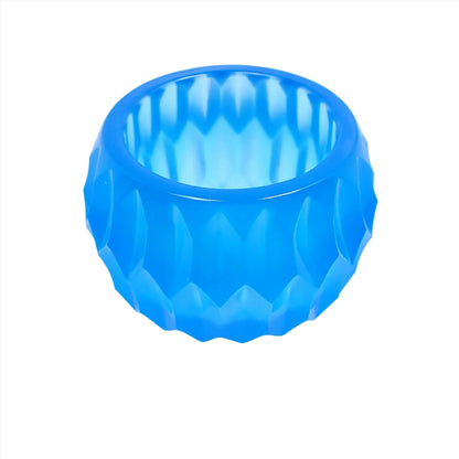 Angled view of the handmade resin small succulent pot decorative bowl. It is neon blue in color and has a rounded shape with an indented hexagon pattern.