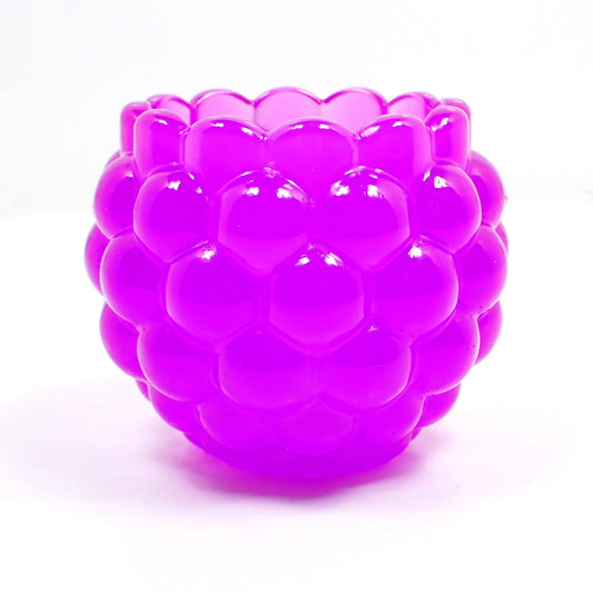 Side view of the handmade resin decorative bowl. The resin is neon purple in color. It has a rounded shape with a bumpy round ball textured on the outside. The top tapers slightly and has a scalloped edge.