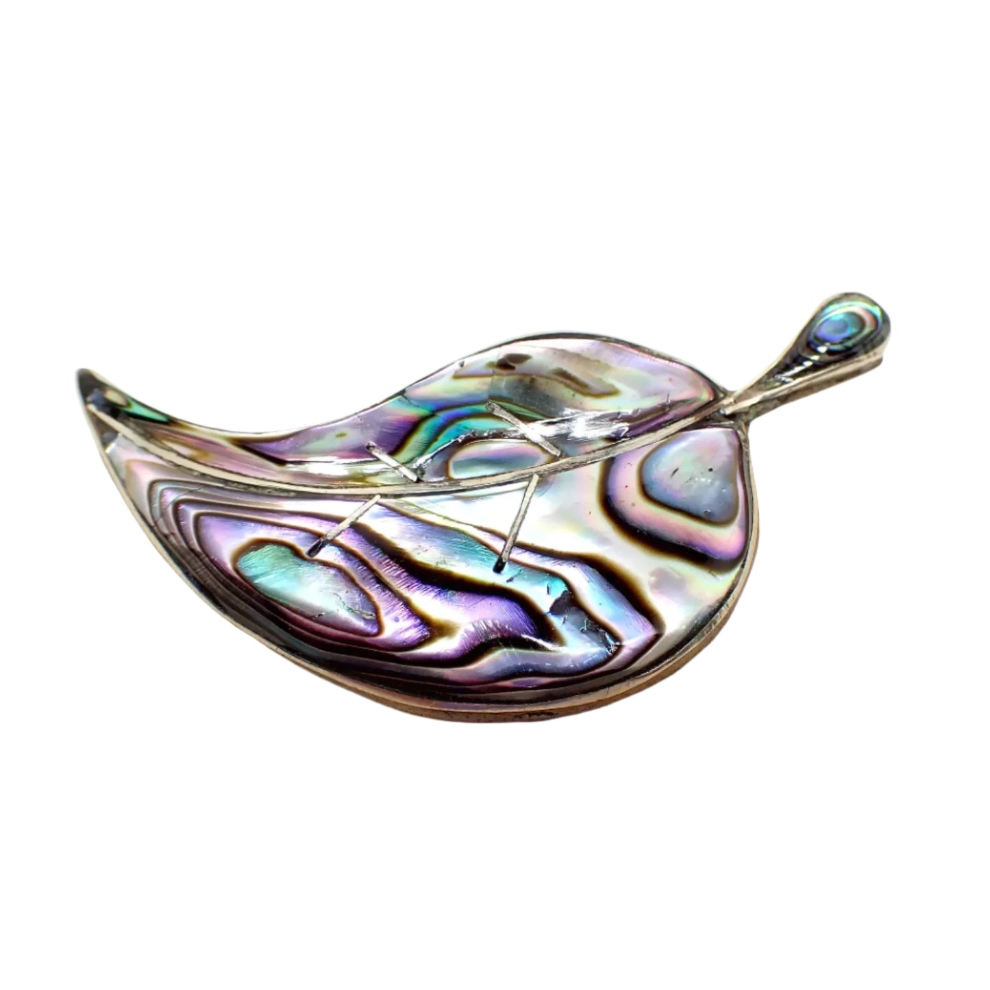 Angled view of the Alpaca Mexico leaf brooch. It's shaped like a curved leaf with silver tone color metal. The front of the leaf and stem have iridescent inlaid abalone shell.