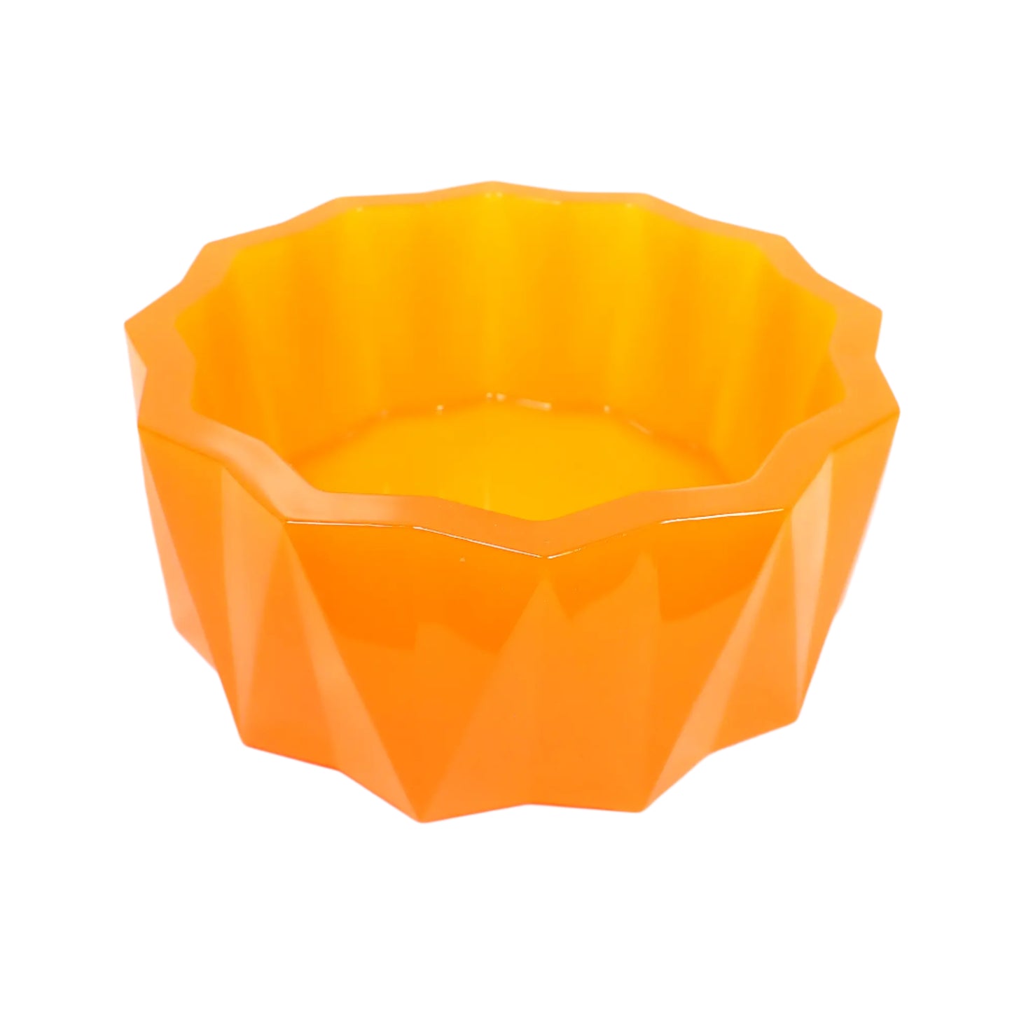 Angled side view of the large handmade neon orange resin faceted decorative bowl. It has a sun like faceted shape on top and a faceted triangle design on the sides with the triangles alternating in direction. The resin is shiny and semi translucent in a bright neon orange color.
