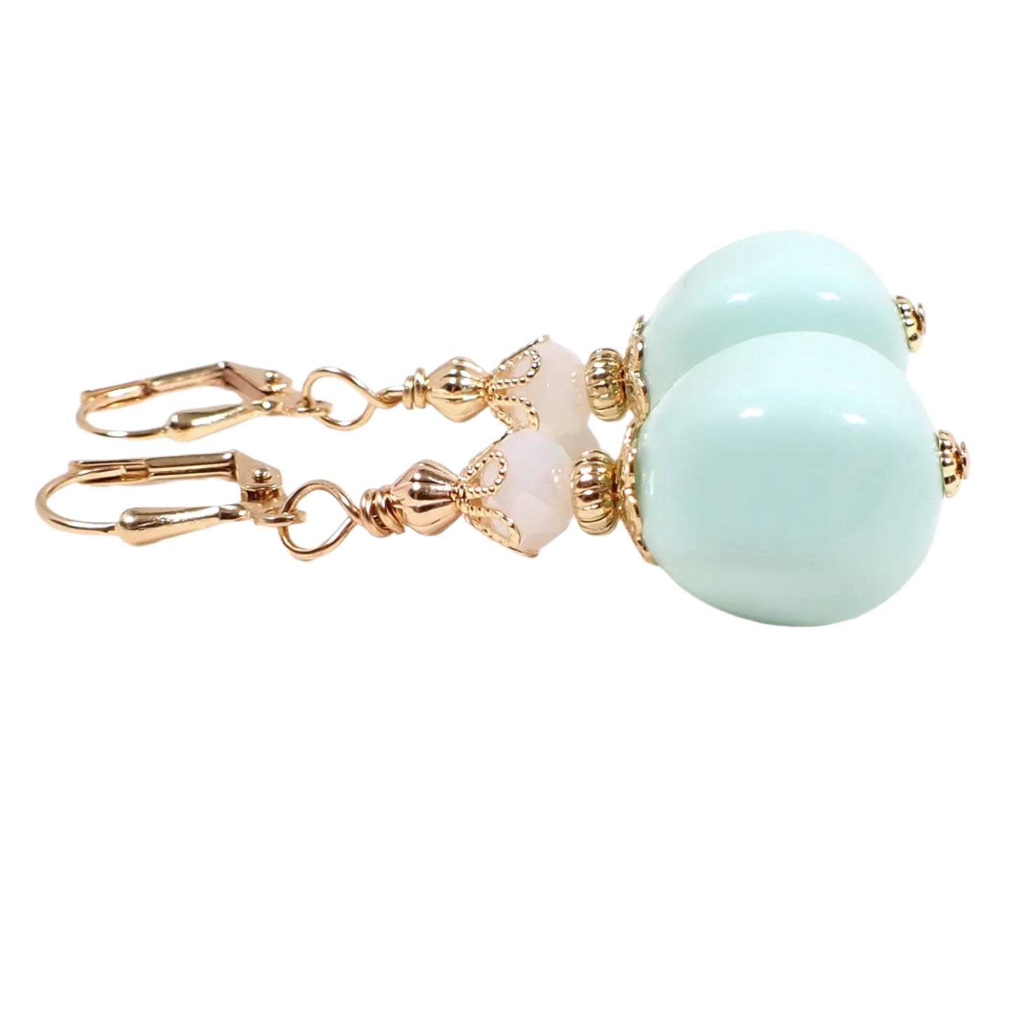 Side view of the handmade nugget drop earrings. They are beaded with faceted white glass beads at the top and light lime cream green vintage German acrylic beads on the bottom. The earrings are shown with lever back pierced components at the top, though other choices are available.