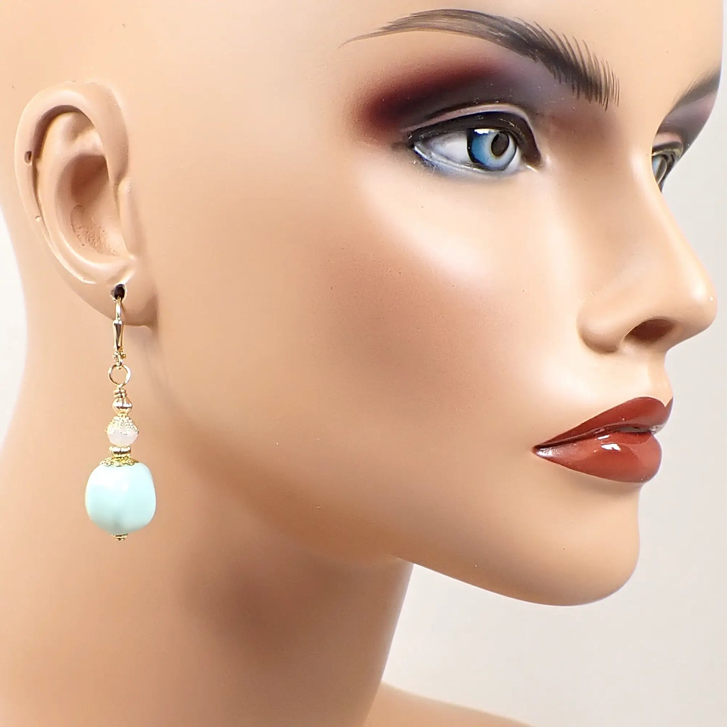 Image of the handmade pastel green nugget earrings on a full sized mannequin to show how they would look worn and to give an indication of size.