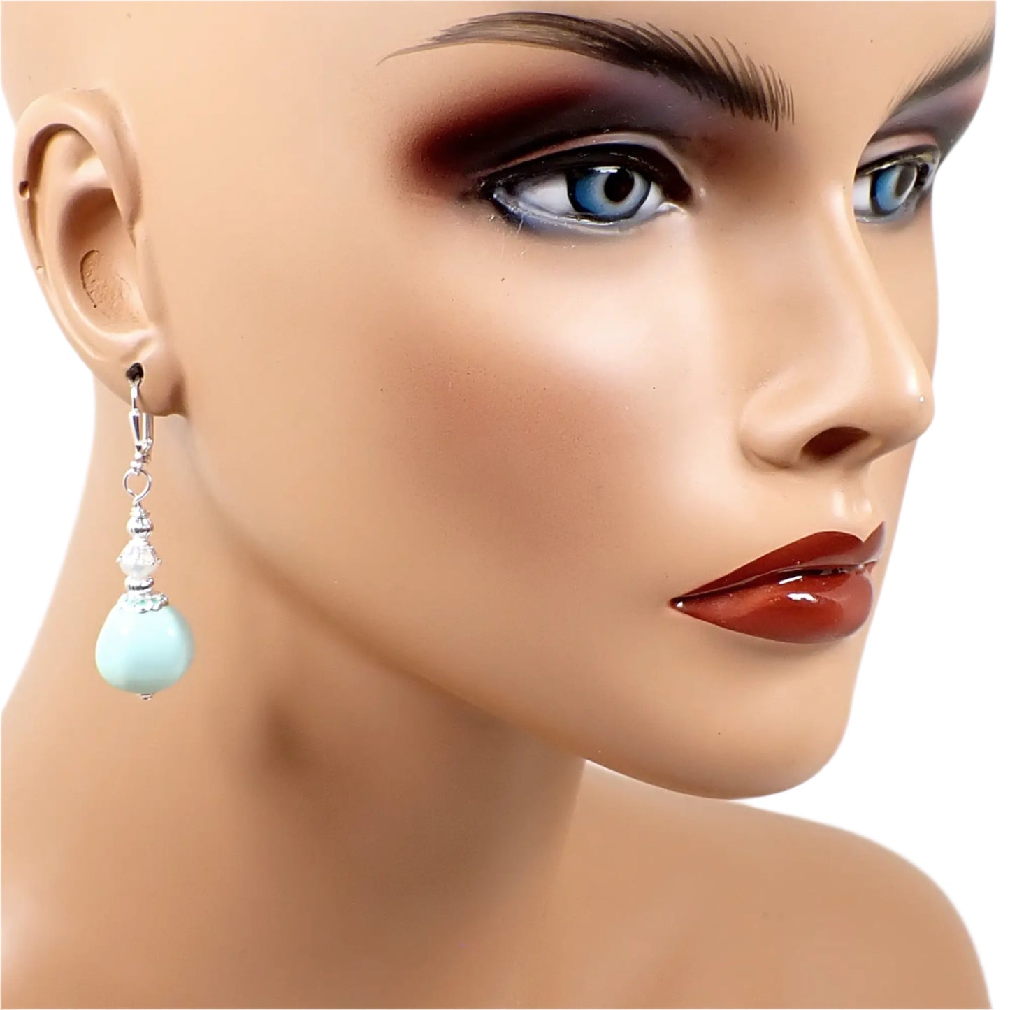 Image of one of the handmade beaded light green nugget drop earrings on a full sized mannequin showing how they would look worn and to give an indication of size.