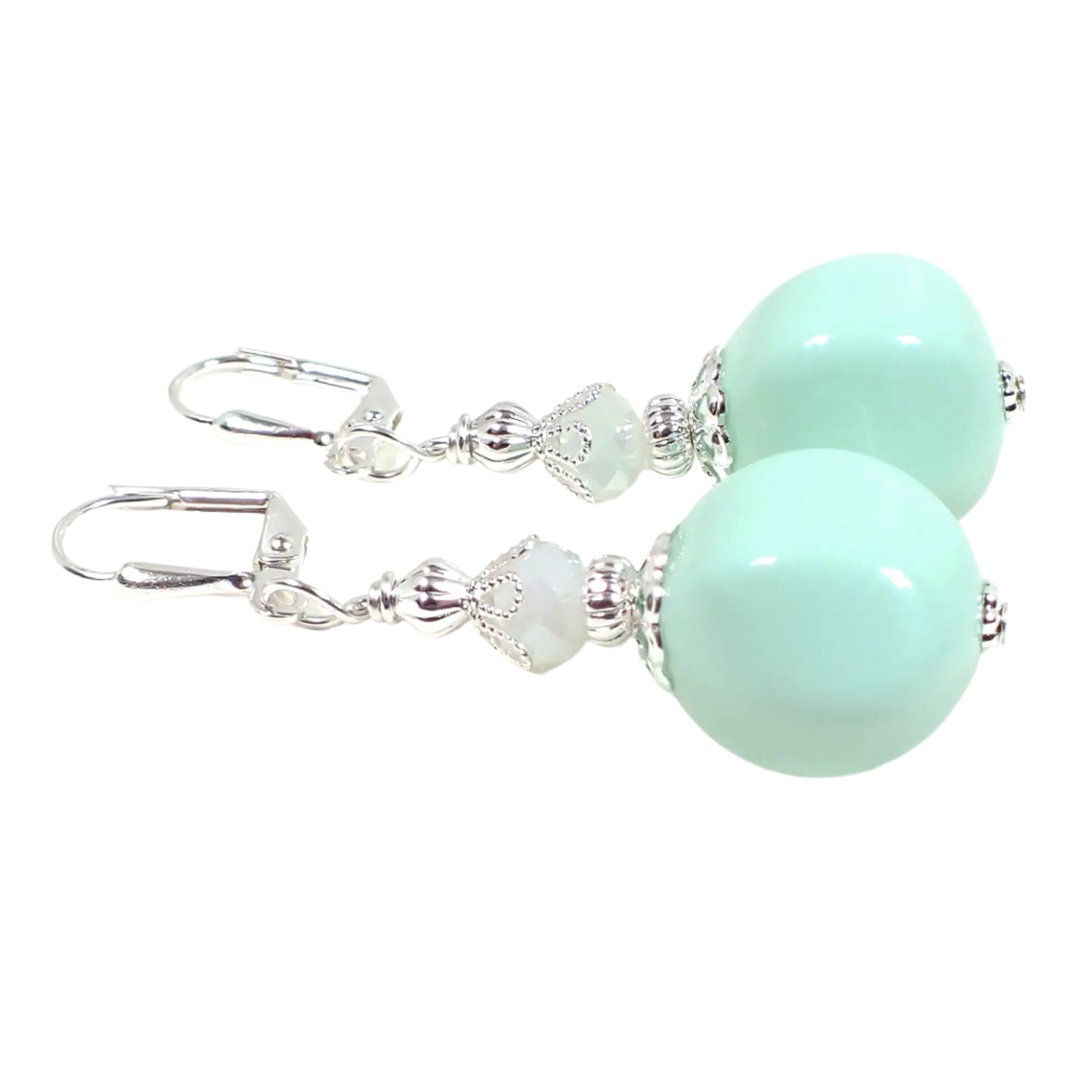 Side view of the handmade nugget drop earrings. They are beaded with faceted white glass beads at the top and light lime cream green vintage German acrylic beads on the bottom. The earrings are shown with lever back pierced components at the top, though other choices are available.