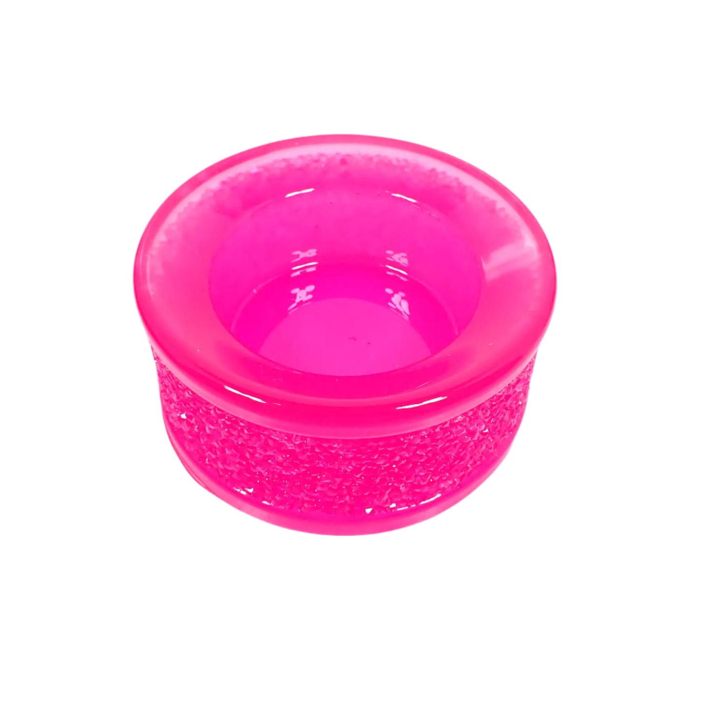 Angled top view of the handmade neon pink resin tealight candle holder showing more of the inside opening where the tea light candle would go. The inside is shiny and smooth.