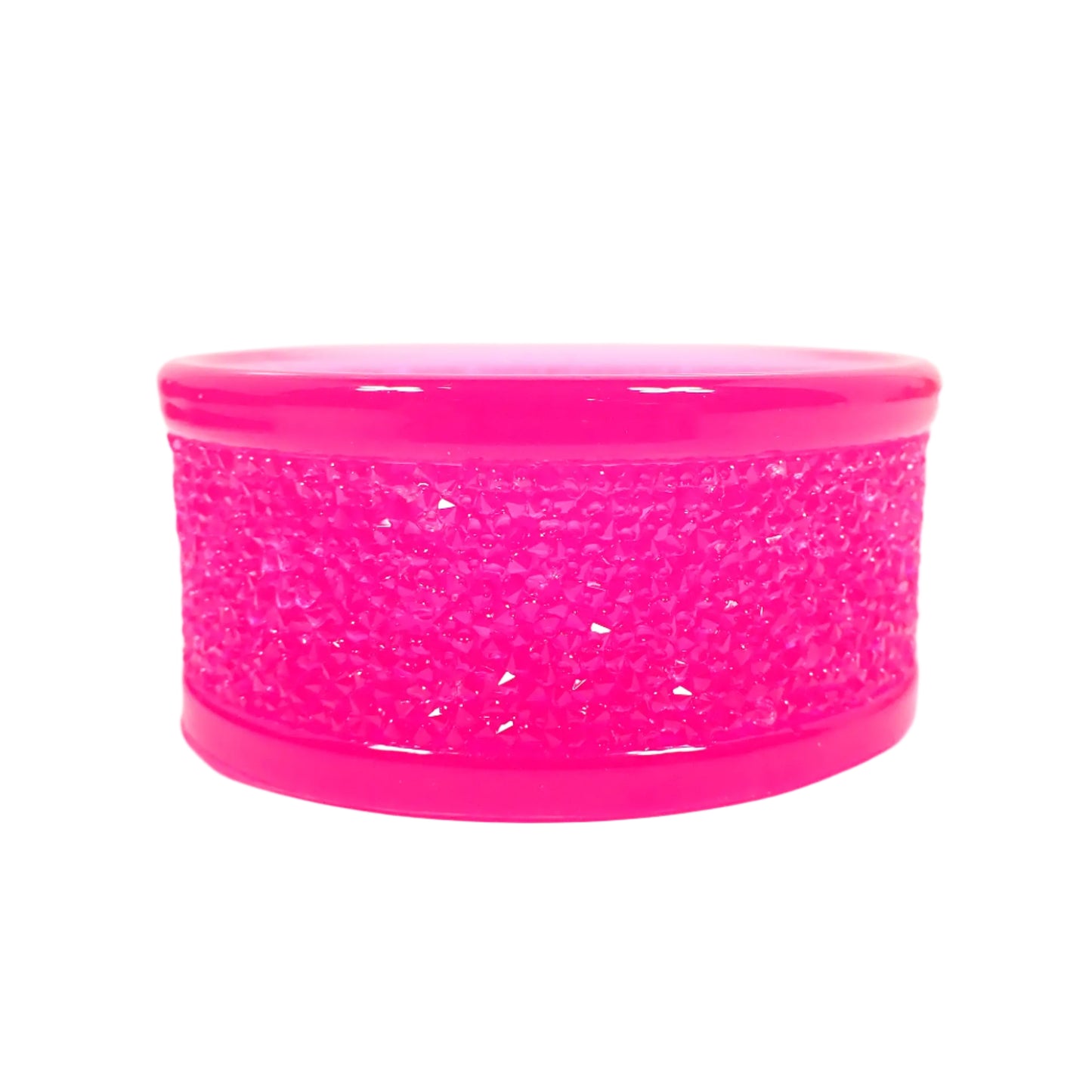 Closeup side view of the handmade tealight candle holder to show more of the faux druzy like appearance around the outside of it. It looks like tiny crystal shapes that are shiny and sparkly when the light hits it. The resin is semi translucent and bright neon pink in color. Great for adding sparkle and a pop of color to your home decor.
