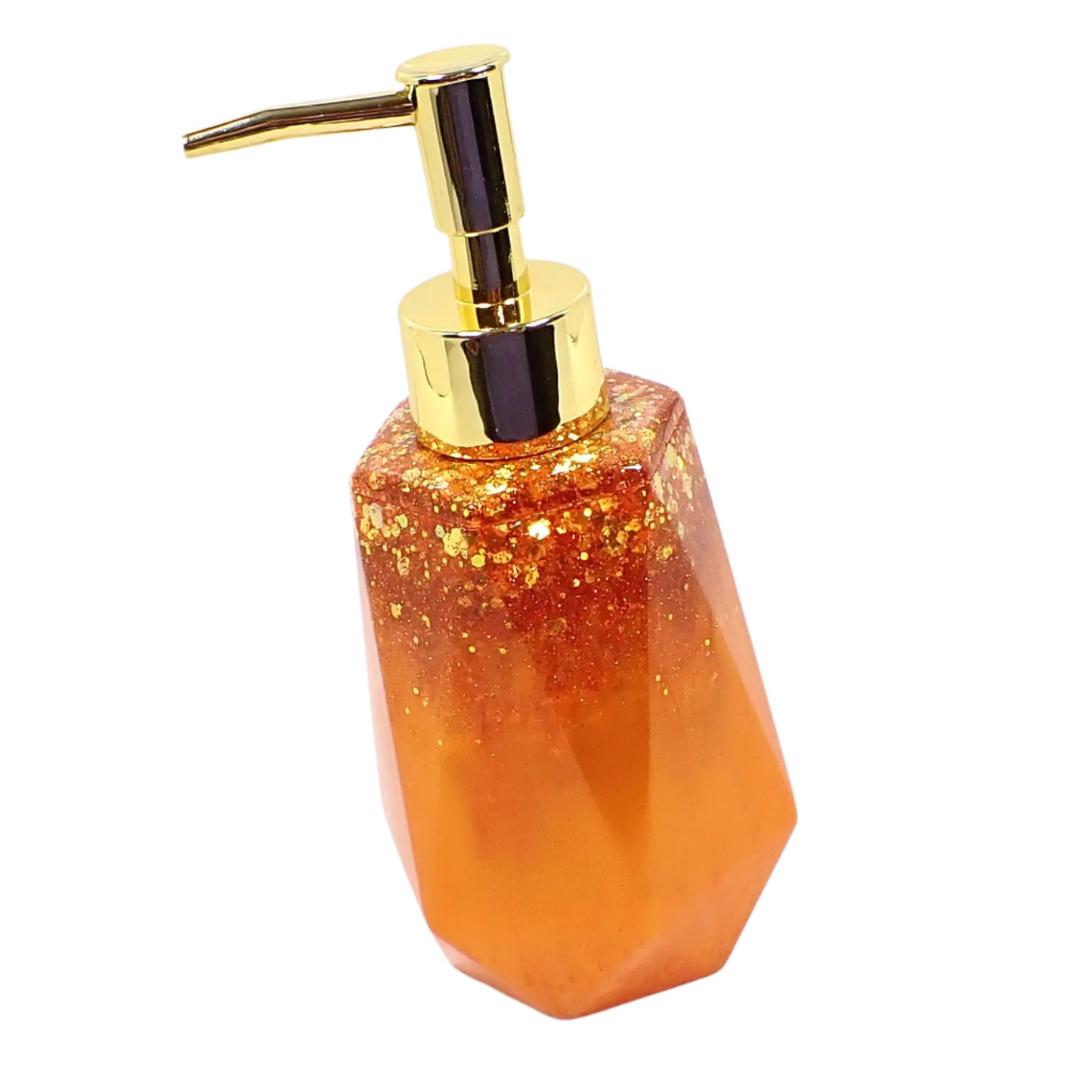 Angled side view of the handmade resin soap dispenser showing more of the faceted geometric design. It has pearly orange resin with iridescent chunky orange and gold color glitter at the top. The dispenser pump shown in the image is gold in color.