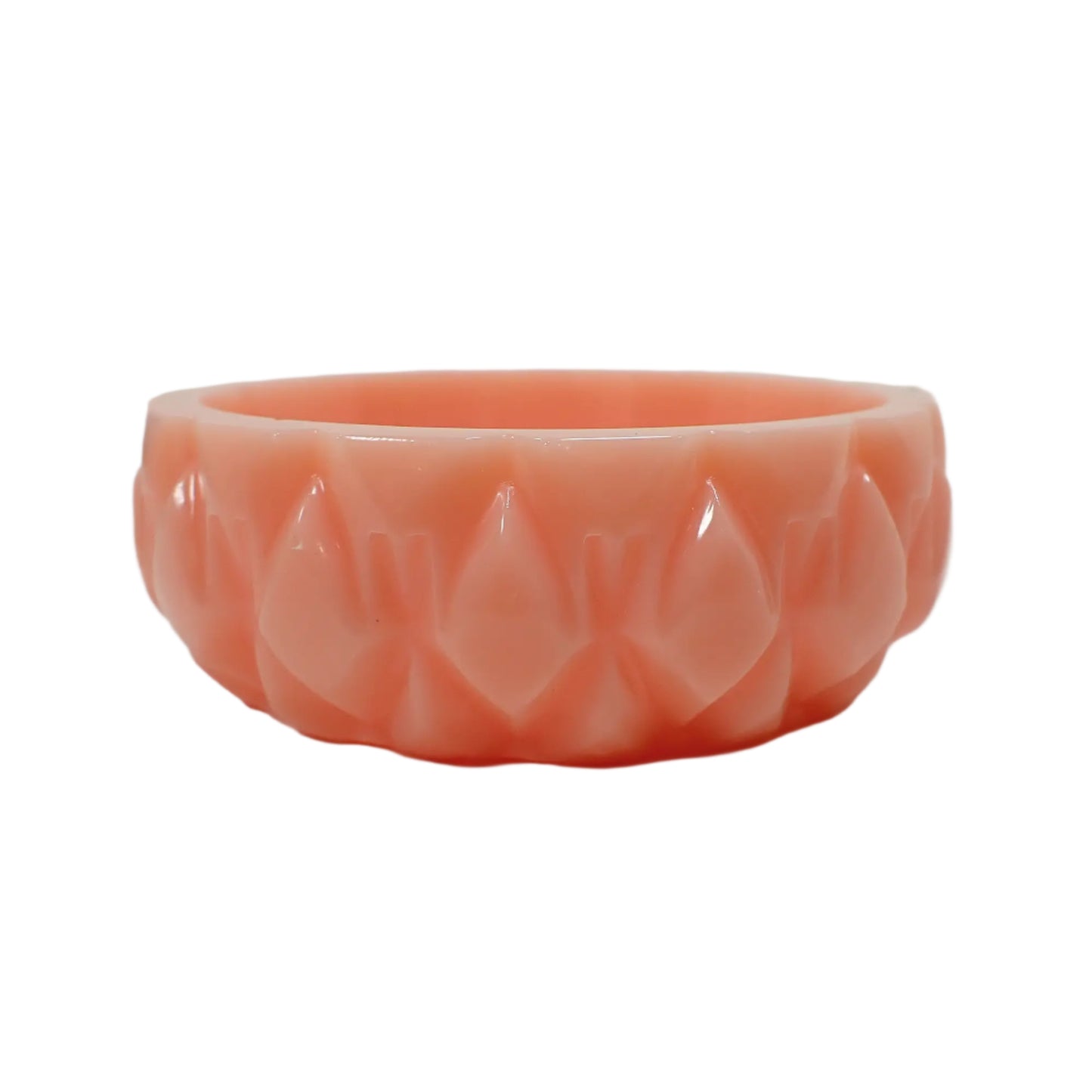 Side view of the handmade pastel peach resin ring dish showing the diamond shape pattern along the outside. It is designed to look like a carved pattern, though it is not.