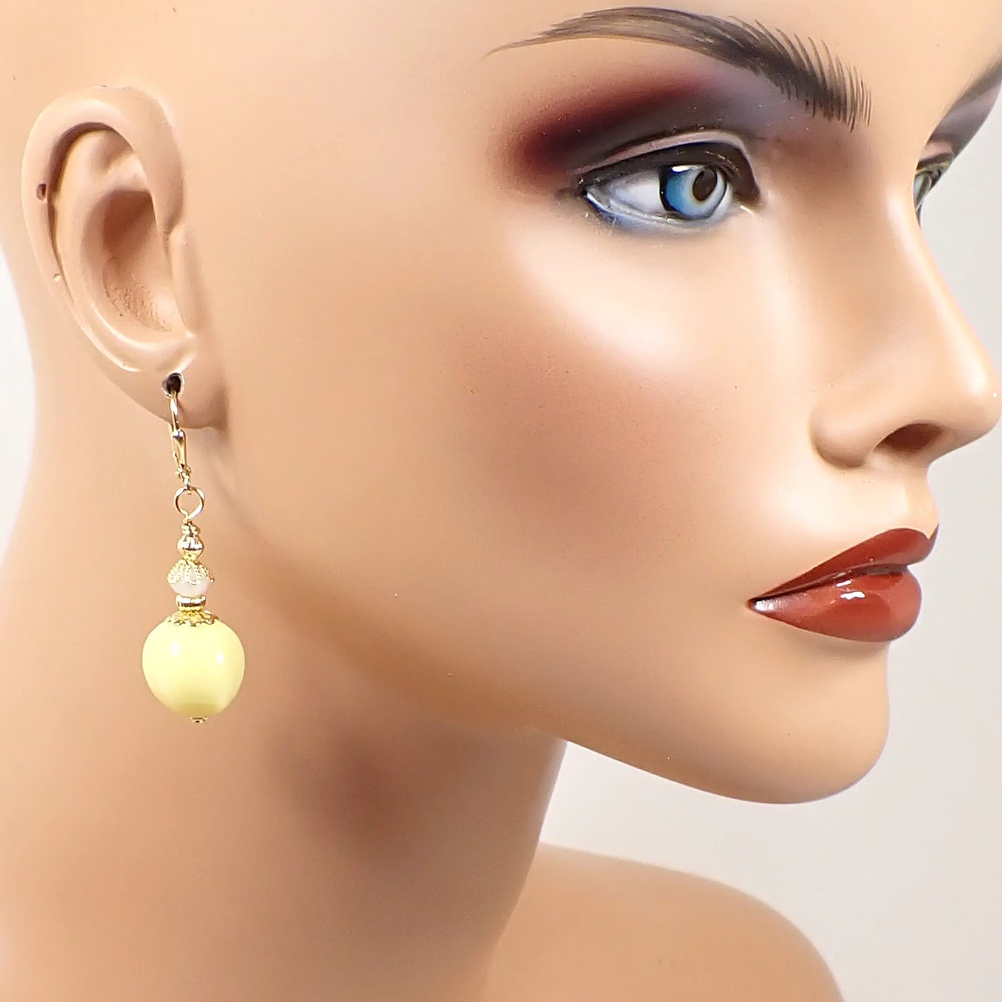 Image of the handmade pastel yellow nugget earrings on a full sized mannequin to show how they would look worn and to give an indication of size.