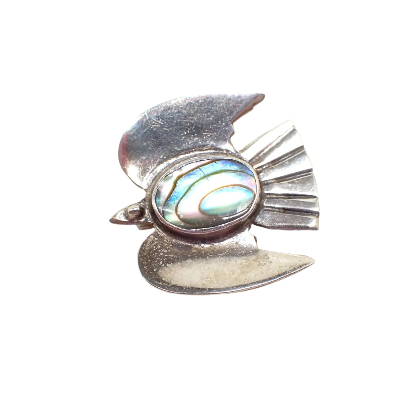Top view of the Mid Century vintage small bird brooch pin. The sterling silver has darkened some with age. The brooch has a flat style head, wings, and tail with etched design for the tail feathers. There is an oval abalone cab in the middle for the birds body.