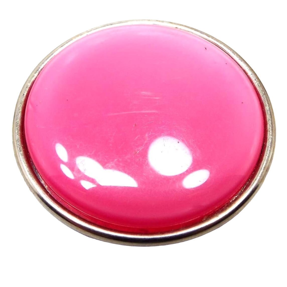 Front view of the Mid Century vintage moonglow lucite scarf clip. It is round and pink in color. The setting is silver tone color metal. Some scuff scratching from age can be seen on the plastic cab. Whites spots showing are reflections from lights during photography.
