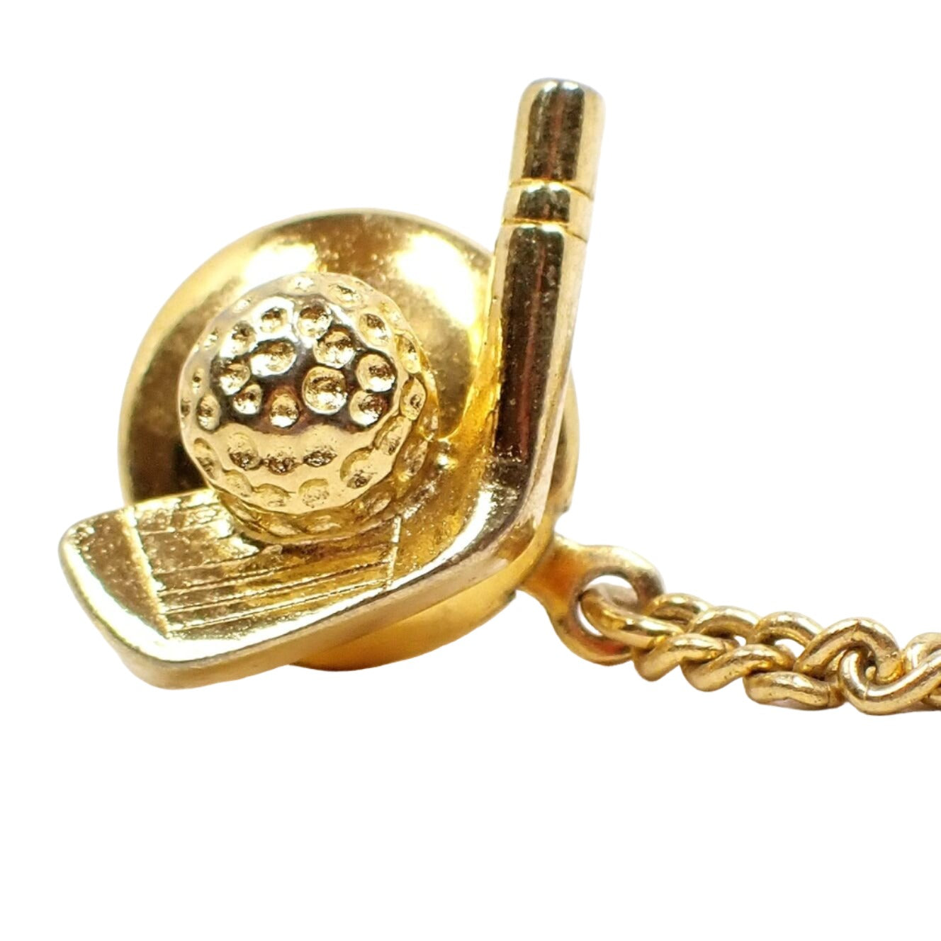 Front view of the retro vintage golfing tie tack. It is gold tone plated in color and has a golf club head and ball design.