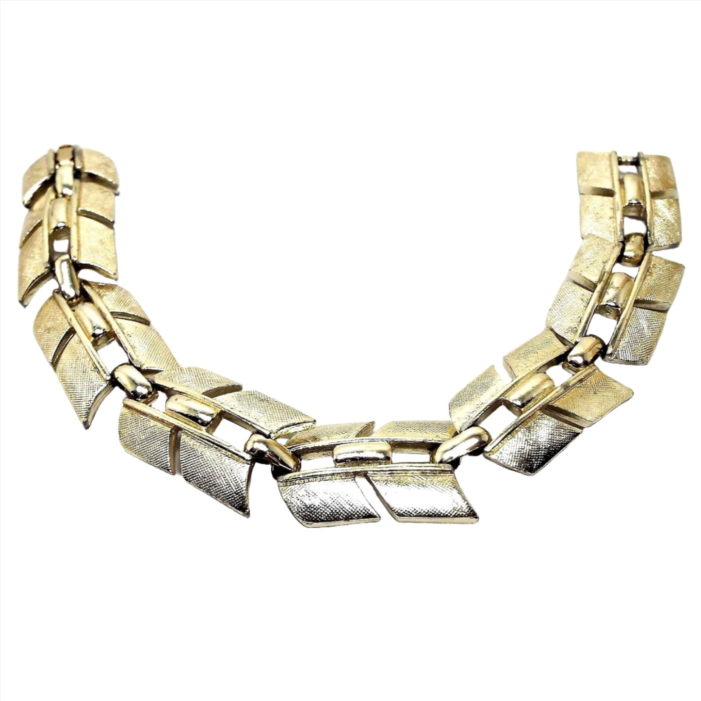 Top view of the retro vintage Sarah Coventry link bracelet. The metal is textured gold tone in color. It link has an angled design. There is a snap lock clasp on the end.