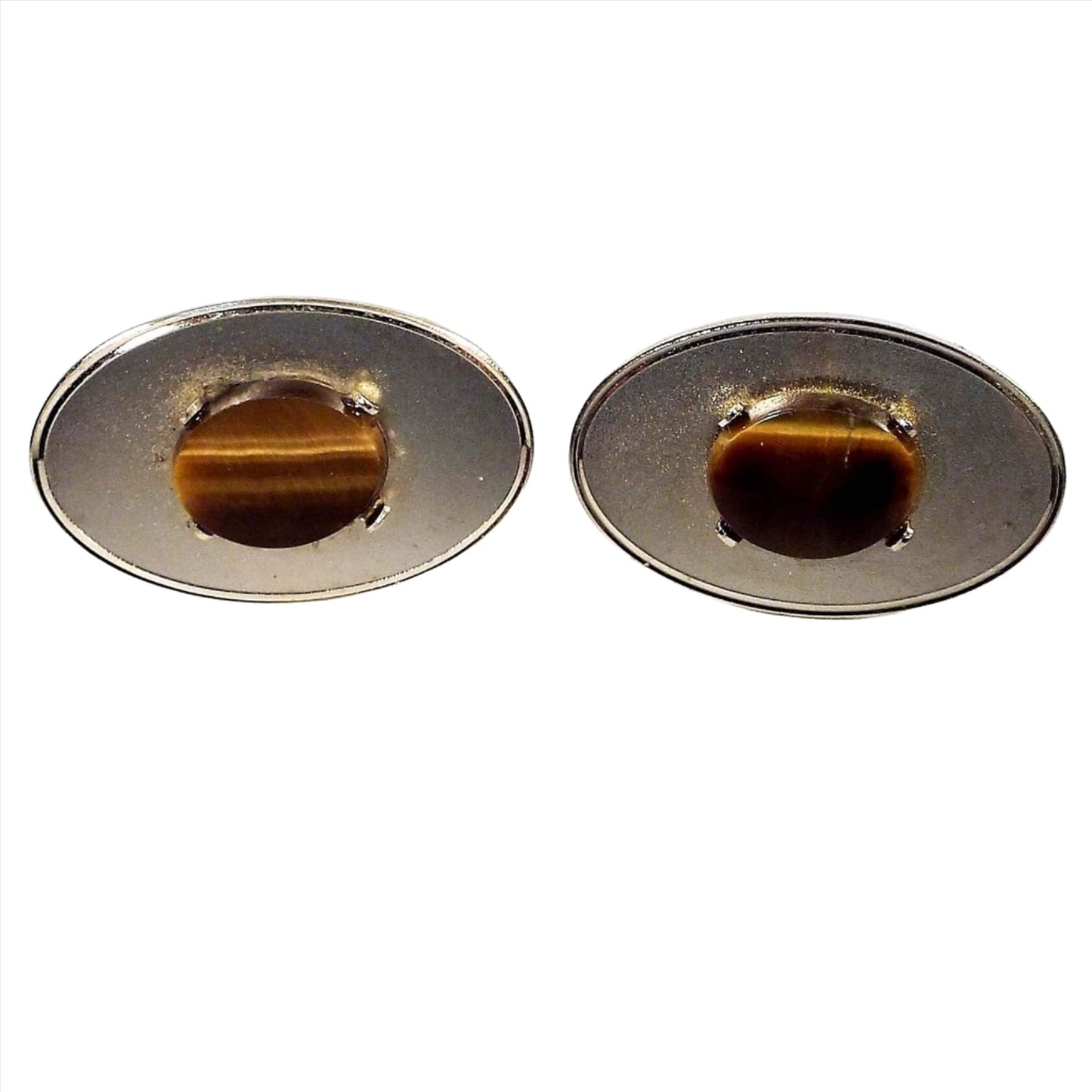 Front view of the Mid Century vintage Dante gemstone cufflinks. They are oval in shape and have matte gold tone color fronts. In the middle are oval tiger's eye gemstone cabs.