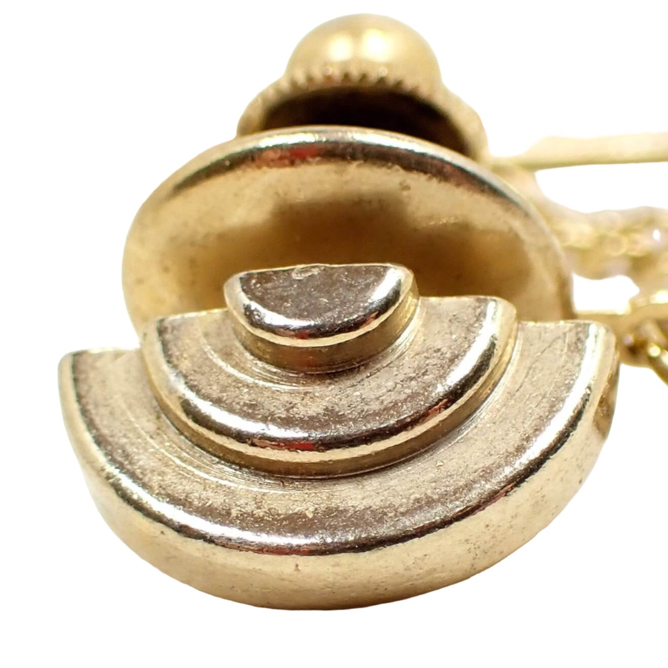 Enlarged front view of the Mid Century vintage tie tack. It is gold tone plated in color and has a stacked curve design.