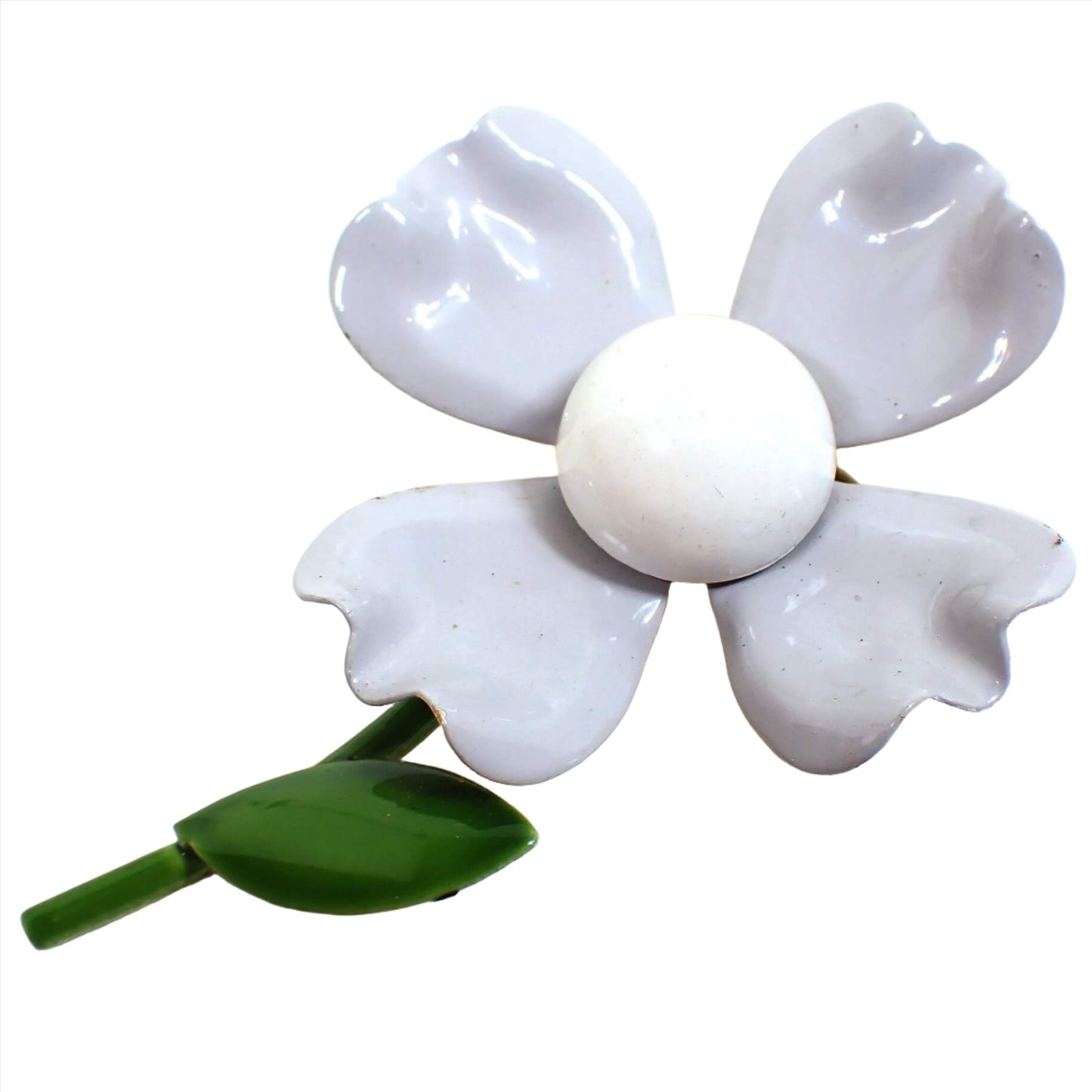 Front view of the Mid Century vintage enameled floral brooch pin. It is shaped like a large flower with four gray petals and a light gray center. The stem and leave are green. There is some wear showing on the enamel around the very edges of the flower petals.