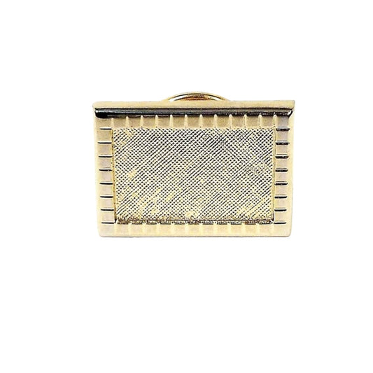 Front view of the retro vintage tie tack. The metal is gold tone plated in color. It is rectangle shaped with a square pattern around the outer edge. The inside front has a matte textured design.