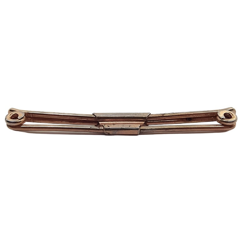Side view of the 1940's Swank 50 vintage collar clip. The metal is a darkened gold tone in color. There are small coils at the ends.