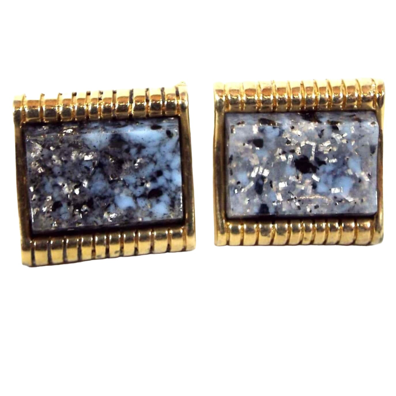 Front view of the retro vintage confetti lucite cufflinks. The metal is gold tone in color. The lucite cabs are mostly blue with black and gray marbled in as well as some silver glitter flakes.