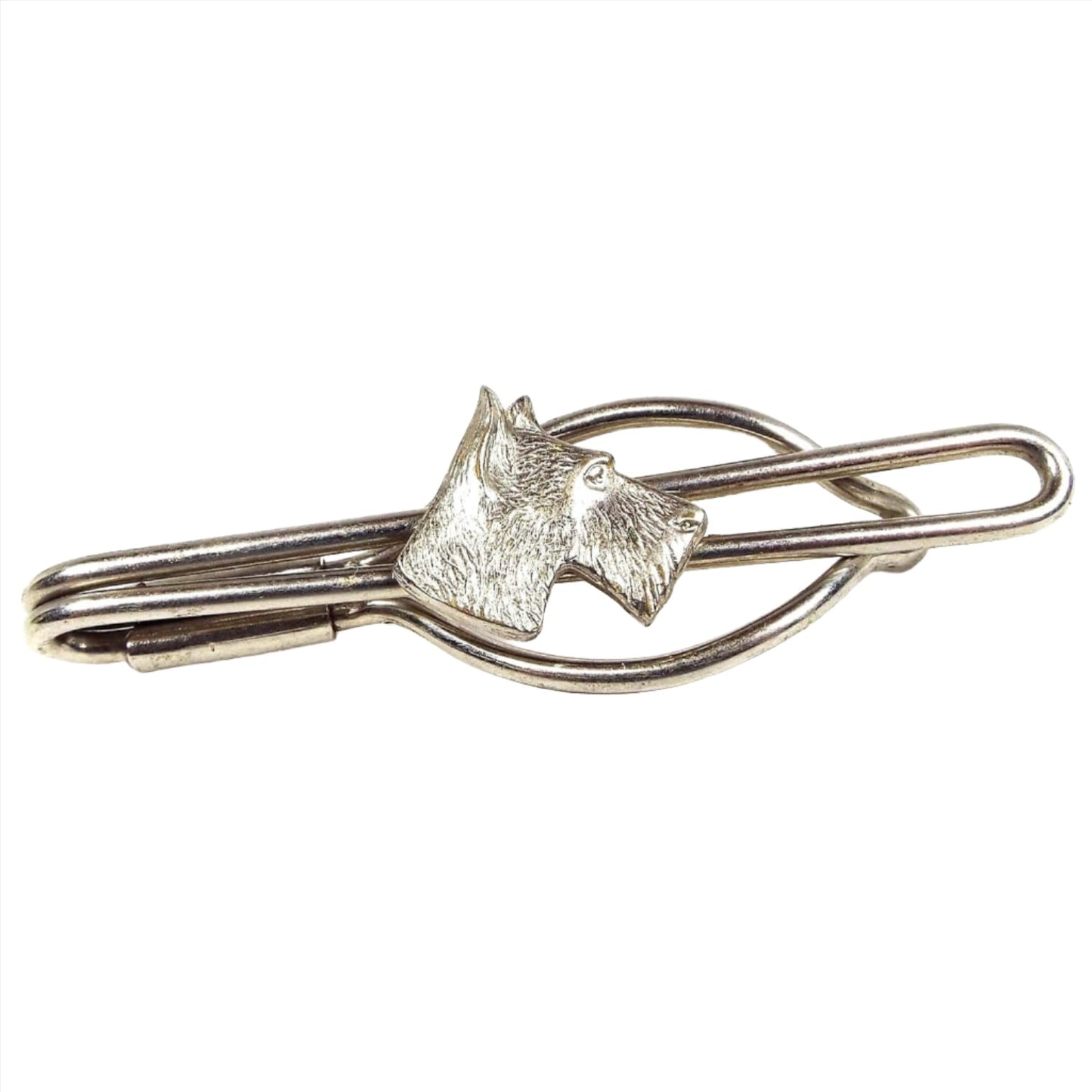 Front view of the 1940's Mid Century vintage dog tie bar. It has an open wire style design with silver tone color metal. In the middle is a head shaped like a Scotty dog.