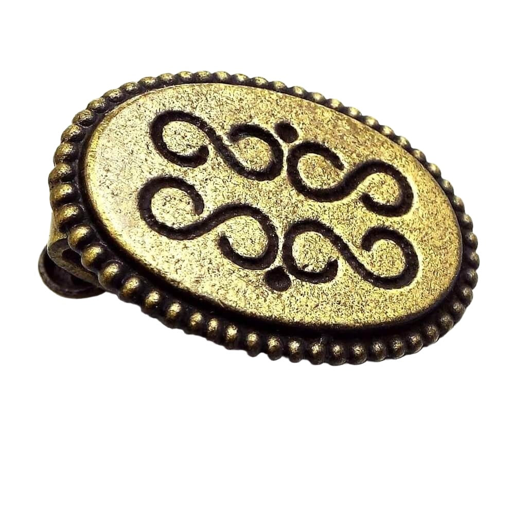 Front view of the retro vintage small oval tie clip. The metal is antiqued brass in color and has an S and dot style design on the front.