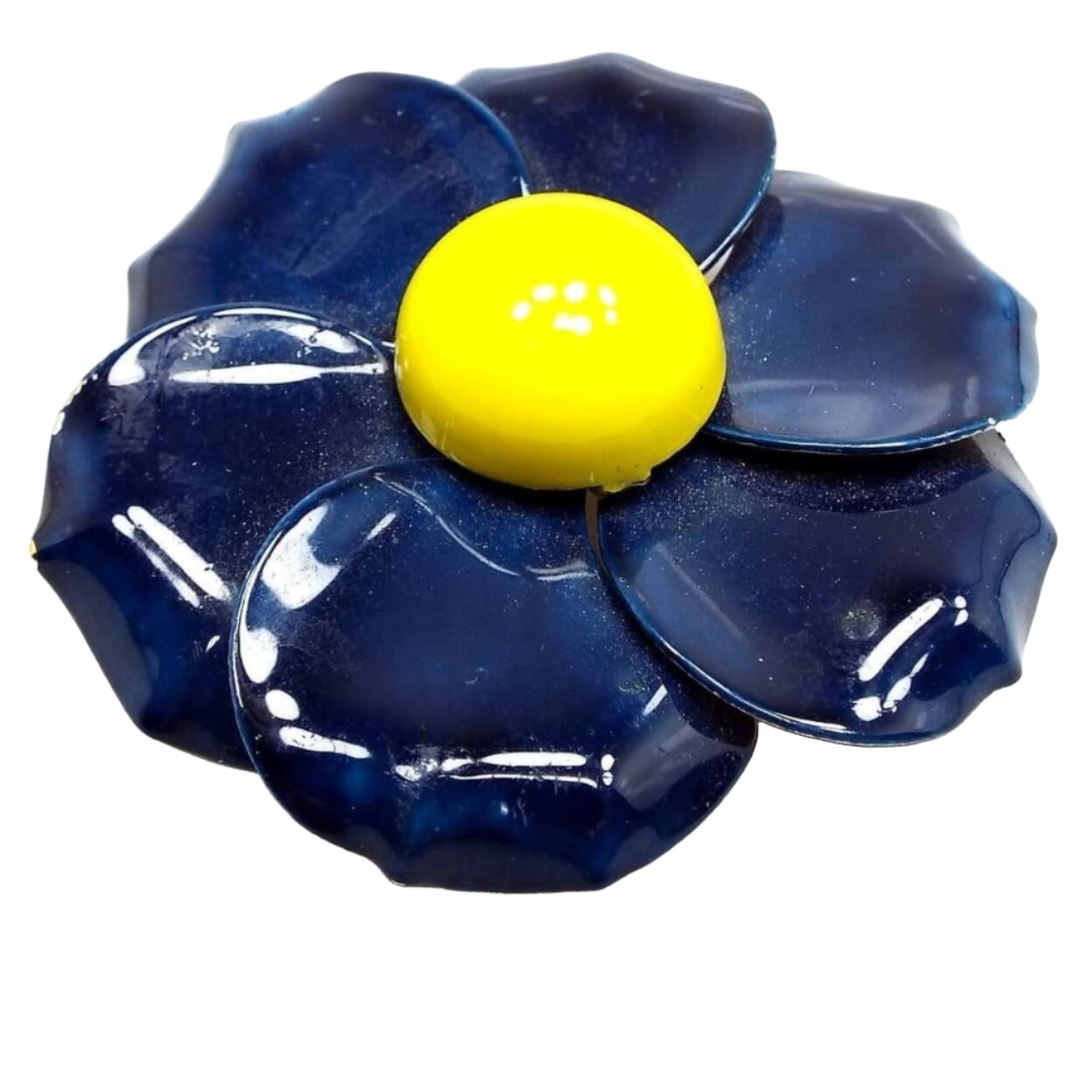 Front view of the Mid Century vintage enameled flower brooch. The brooch is large with slightly overlapping large rounded style petals that have dark blue enamel on the front. The middle of the flower has a raised round area that is bright yellow enameled.