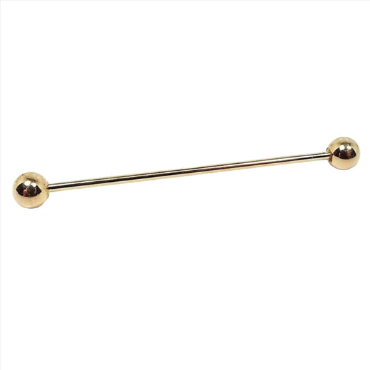 Side view of the round end barbell vintage collar bar. It is gold tone in color with ball ends.