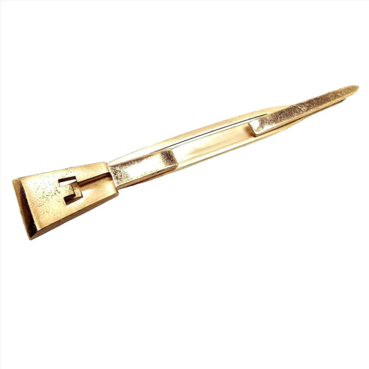 Front view of the 1950's Mid Century vintage Swank initial tie bar. It is gold tone in color and has a block letter E on one end and a point on the other end. The middle is open to slide the tie into.