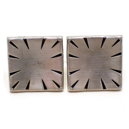 Enlarged front view of the Mid Century vintage Swank modernist cufflinks. The metal is matte silver tone in color. They are shaped like indented squares and have diagonal tapered etched and black painted lines around the edge for an antiqued silver tone appearance.