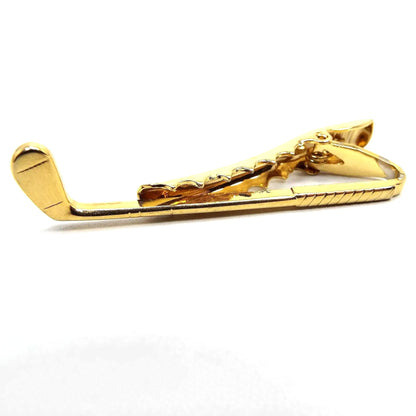 Front view of the retro vintage golf club tie clip. The metal is gold tone in color. It is shaped like a putter.