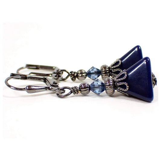 Side view of the small handmade pyramid earrings with vintage lucite beads. The metal is gunmetal gray in color. There are new blue faceted glass crystal beads at the top. The bottom lucite beads are triangle pyramid shaped and dark blue in color.