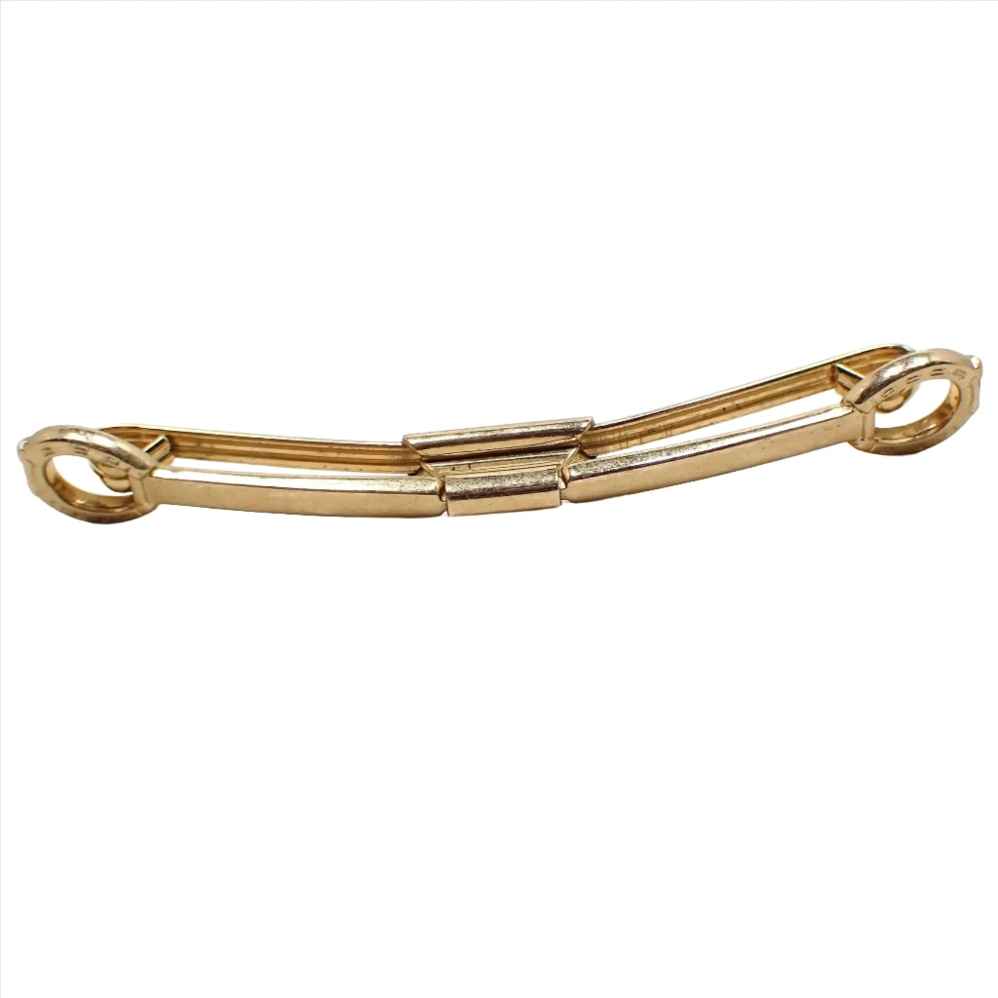 Enlarged front view of the Mid Century vintage Western style collar clip. It is gold tone plated in color and has a horseshoe shaped design on the ends.