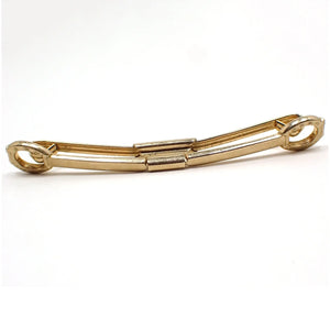 Enlarged front view of the Mid Century vintage Western style collar clip. It is gold tone plated in color and has a horseshoe shaped design on the ends.