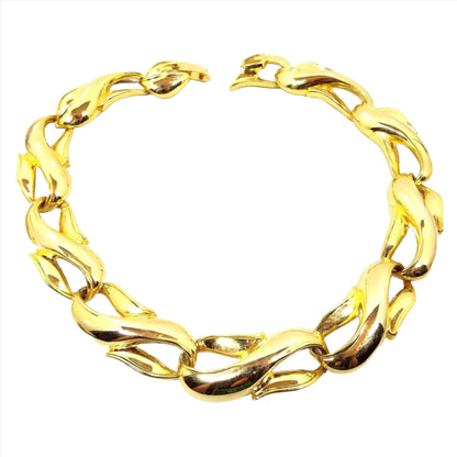 Front view of the retro vintage link necklace. It is gold tone in color with large wide sideways S shaped links. There is a snap lock clasp on the end.