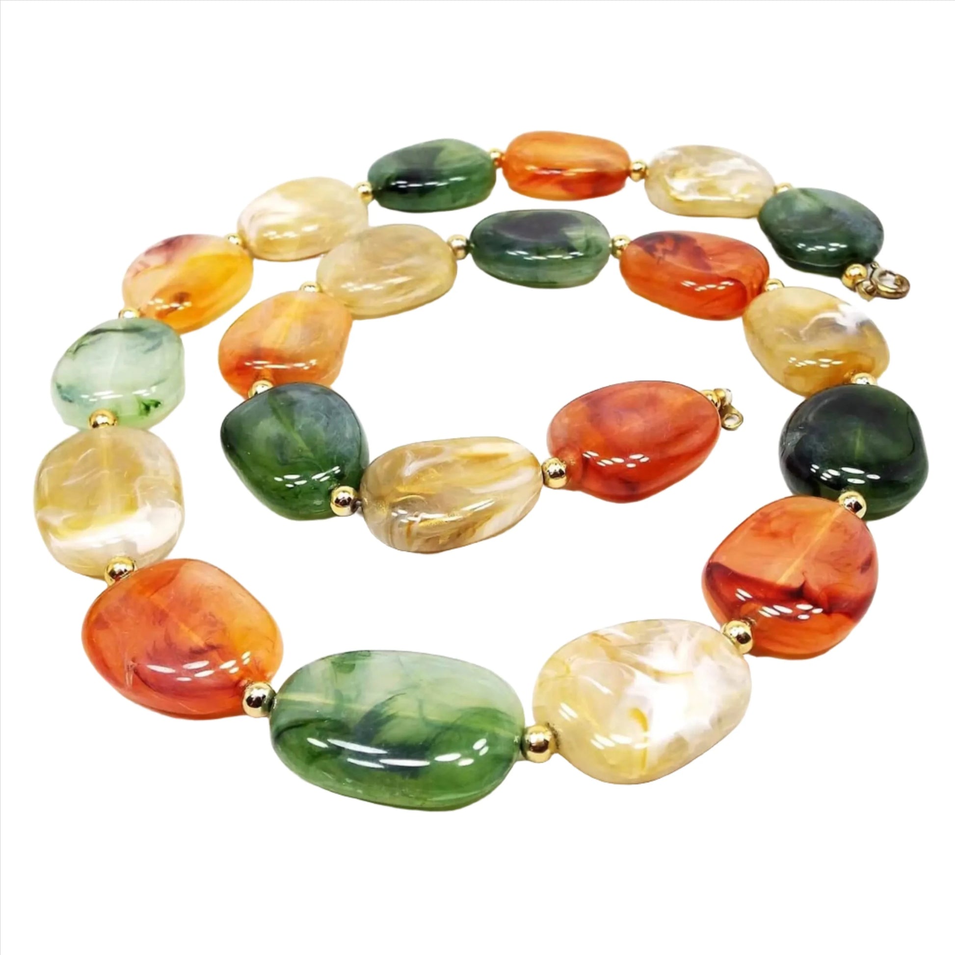 Front view of the retro vintage lucite beaded necklace. The are flat freeform shape beads. There are beads with marbled shades of orange, yellow, and green with small gold tone metal beads in between.