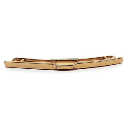 Front view of the 1950's Mid Century vintage Swank collar clip. It is gold tone in color and has a plain classic smooth style curved bar design in the front.