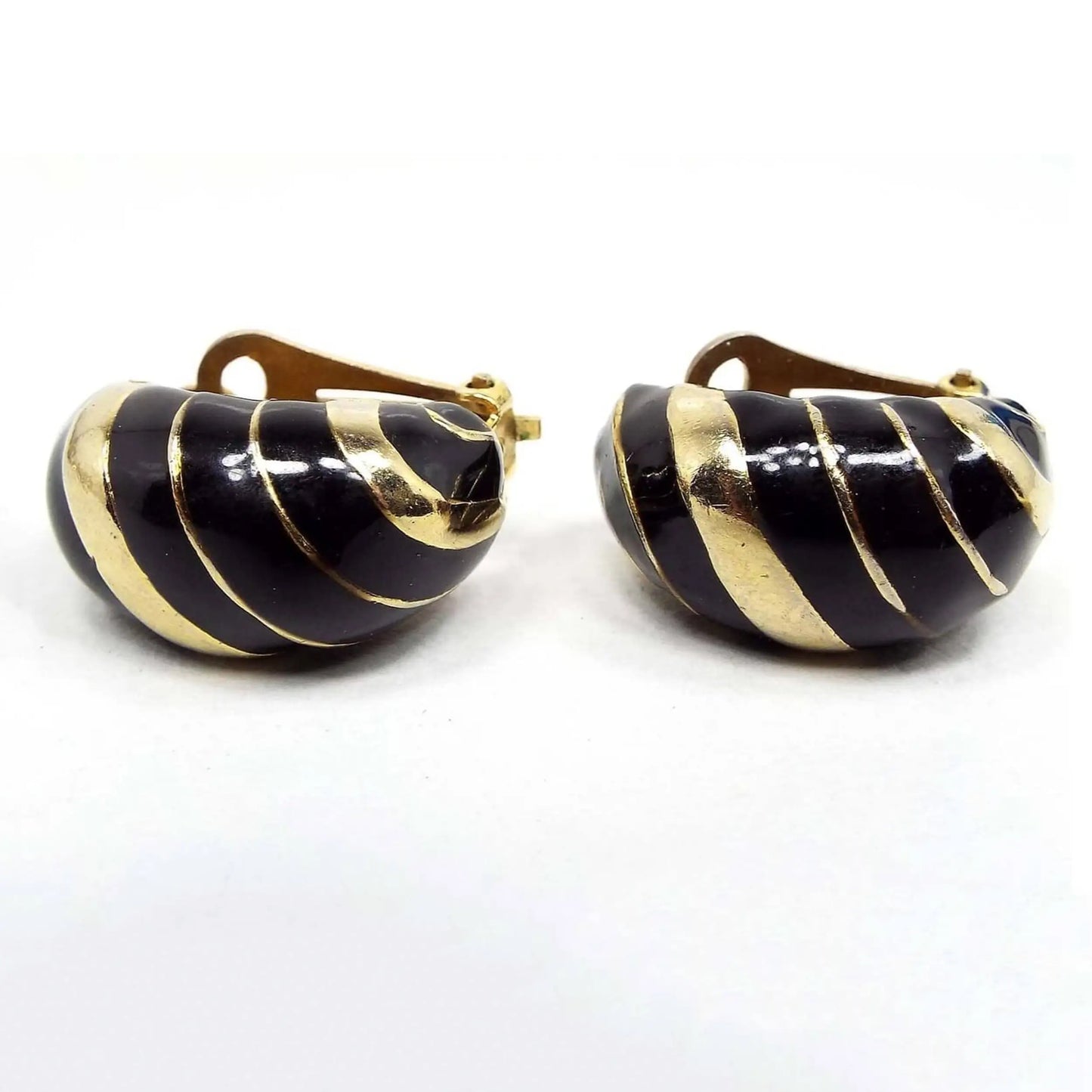 Front view of the retro vintage enameled half hoop earrings. The metal is gold tone in color. There are diagonal bands of enamel and metal.
