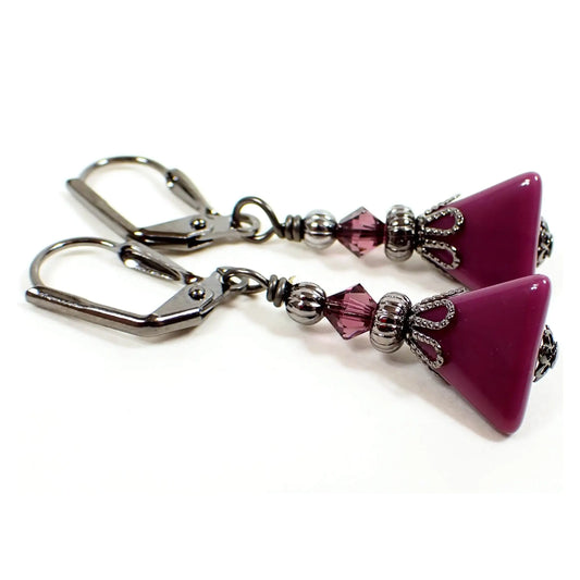 Side view of the handmade pyramid earrings with vintage lucite beads. They are smaller in size with gunmetal gray color metal. There are new purple faceted glass crystal beads at the top. The bottom vintage lucite beads are a eggplant purple in color and are triangle pyramid shaped.