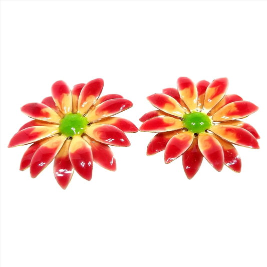 Front view of the Mid Century vintage enameled floral clip on earrings. They have lots of petals with yellow enamel and red tips. The middle is green in color.