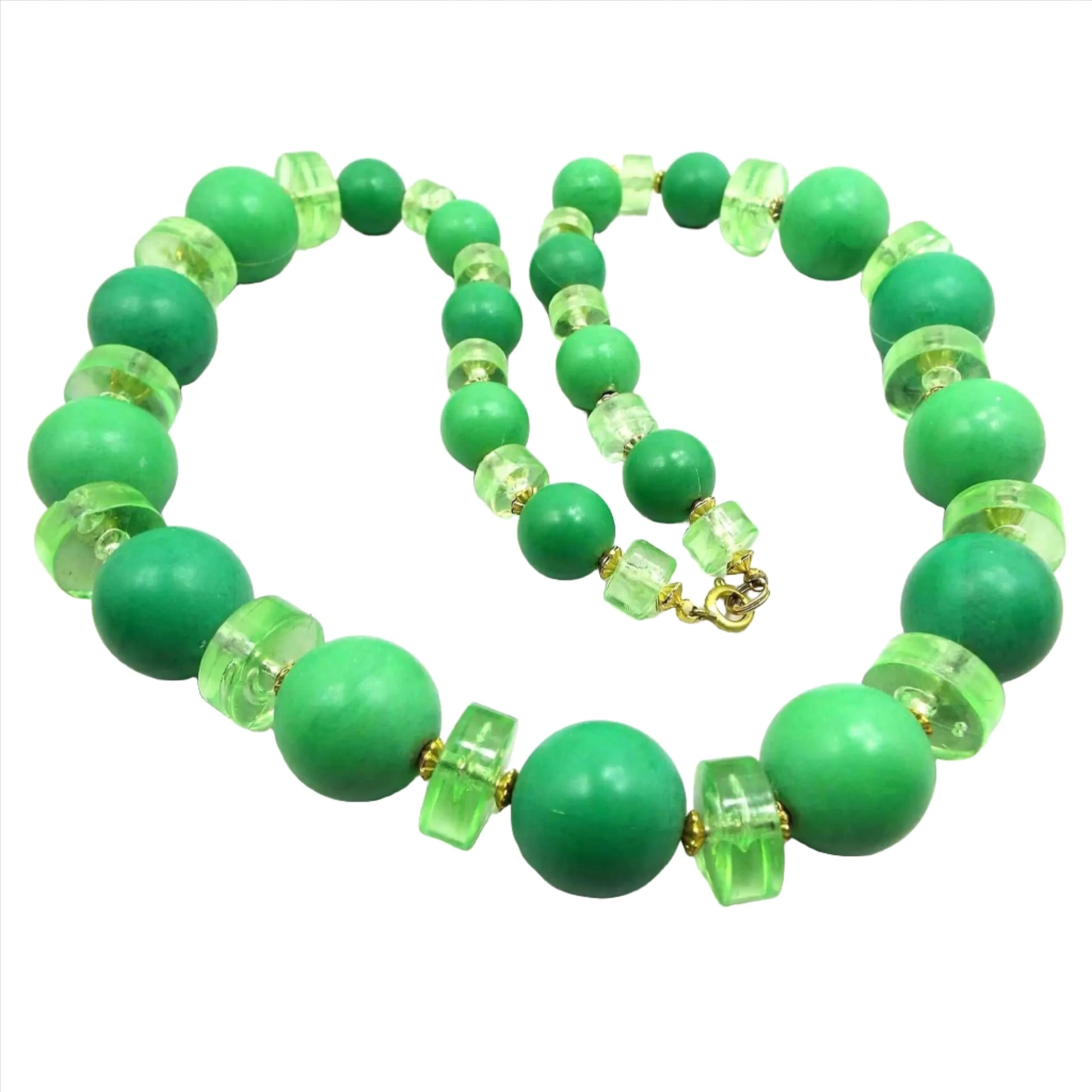 Top view of the Mid Century vintage chunky beaded necklace. It has large round green beads with translucent wide disc beads in between in varying shades of lime green. The metal beads and spring ring clasp are gold tone in color.