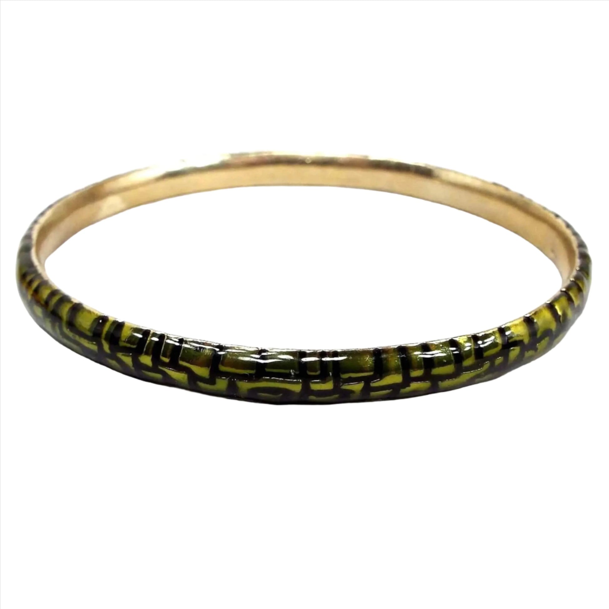 Angled side view of the retro vintage Monet bangle bracelet. The outside edge is enameled green with an angled scale like pattern. The inside of the bangle is gold tone in color.