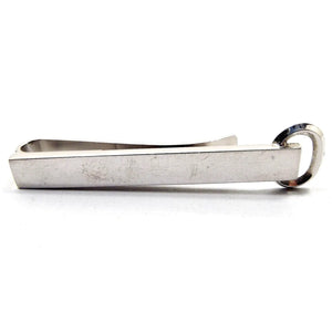 Front view of the silver tone Mid Century vintage Hickok tie bar. It has a long rectangular front with an open oval at the end. It is a slide on style tie bar.