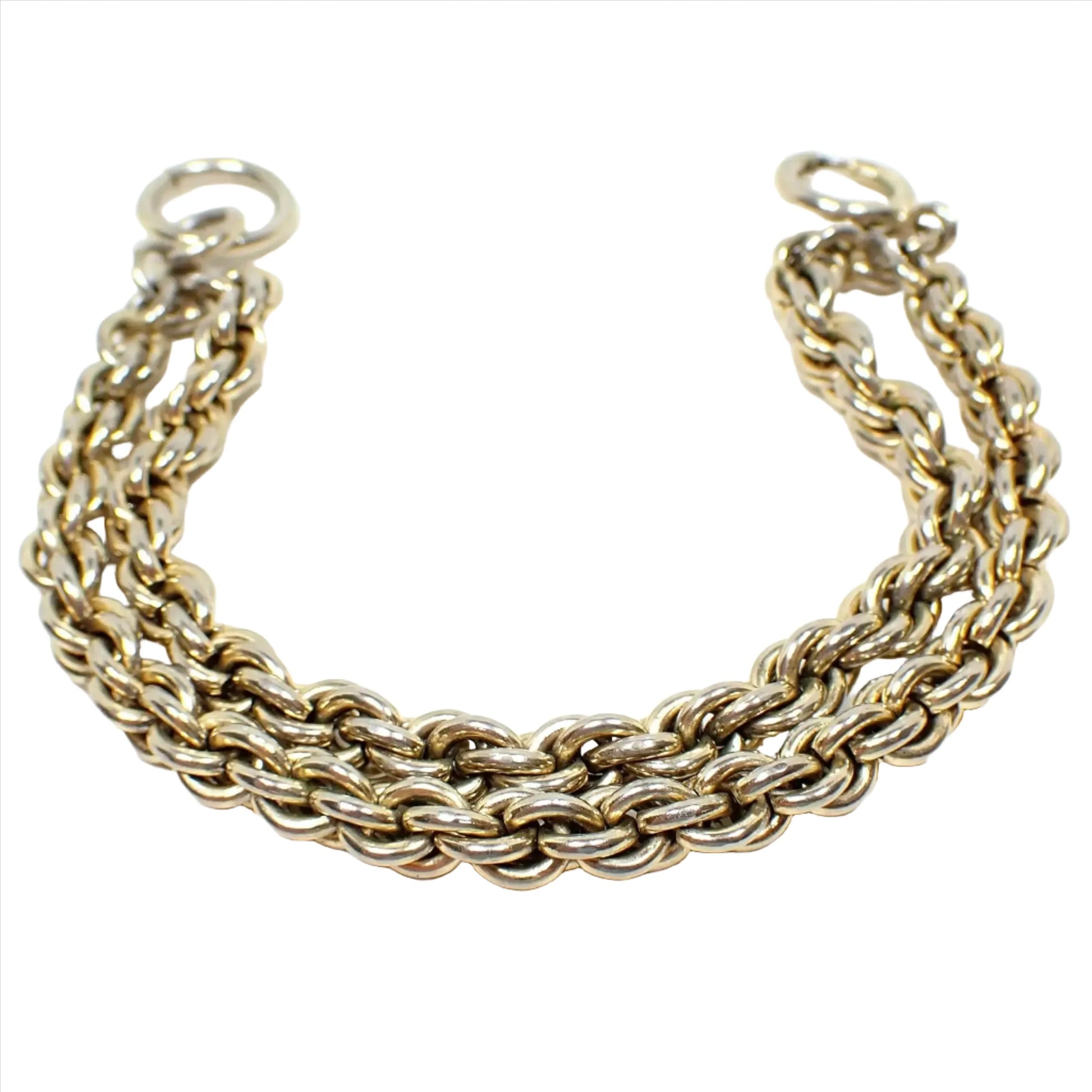 Enlarged view of the Mid Century vintage multi strand chain bracelet. The metal is a light gold tone plated color. There are two strands of wide rope chain attached by a large round jump ring on one end and a large round spring ring clasp on the other.