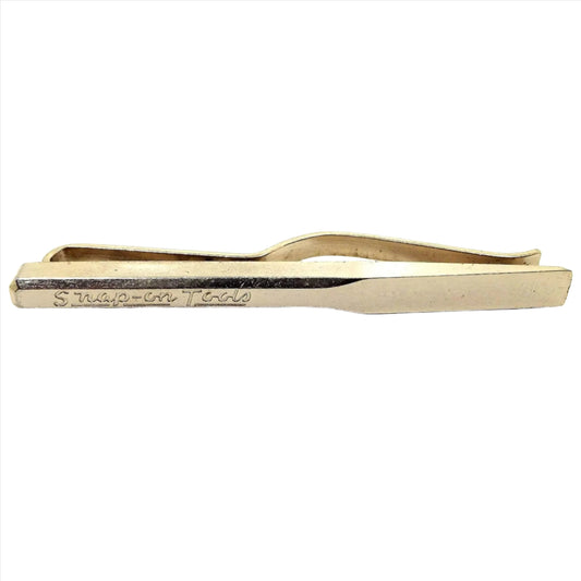 Front view of the retro vintage Snap on Tools Tie bar. It's gold tone in color and is a slide on tie bar style.