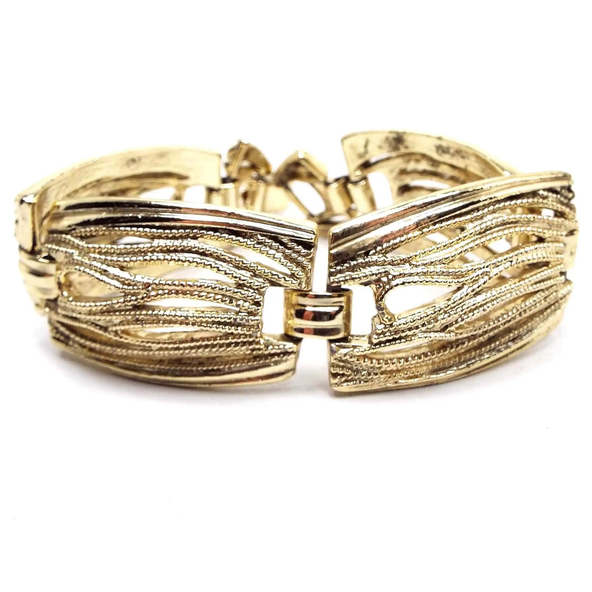 Front view of the Mid Century vintage filigree link bracelet. The metal is gold tone in color. The links are large rectangles with rounded sides and have a cut out filigree design.