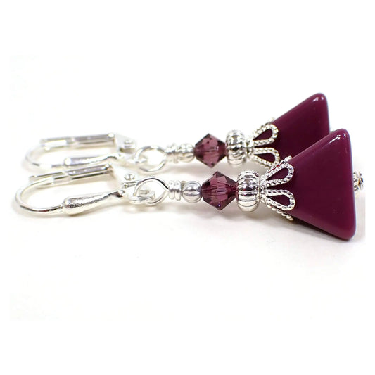 Side view of the handmade pyramid earrings with vintage lucite beads. They are smaller in size with silver plated color metal. There are new purple faceted glass crystal beads at the top. The bottom vintage lucite beads are a eggplant purple in color and are triangle pyramid shaped.