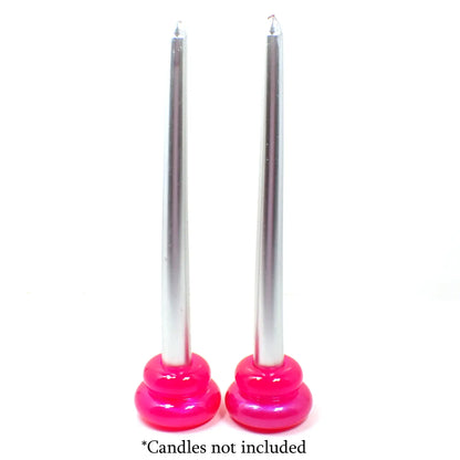 Photo showing how the handmade puffy double ring candlestick holders look with candles in them. The candles being shown are silver in color and the candlestick holders are bright pink. At the bottom are the words "Candles not included."