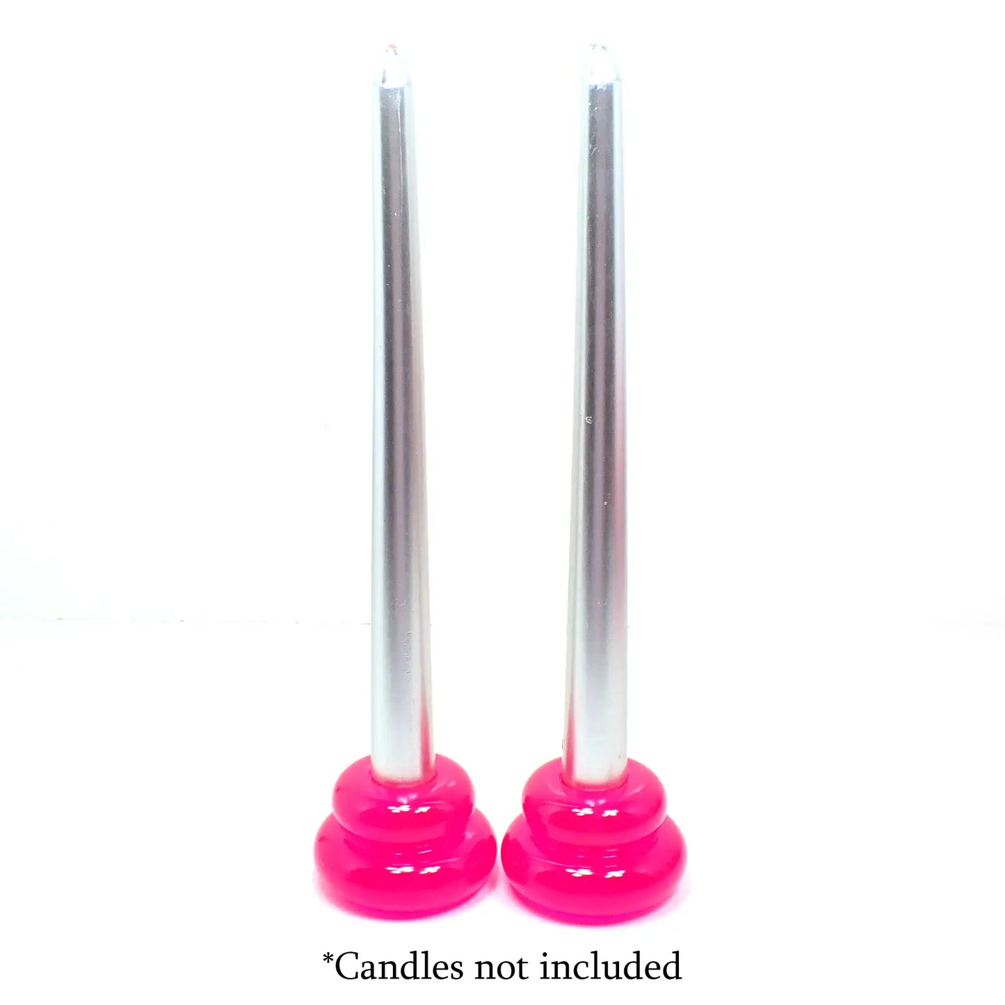 Photo showing how the handmade puffy double ring candlestick holders look with candles in them. The candles being shown are silver in color and the candlestick holders are bright neon pink. At the bottom are the words "Candles not included."